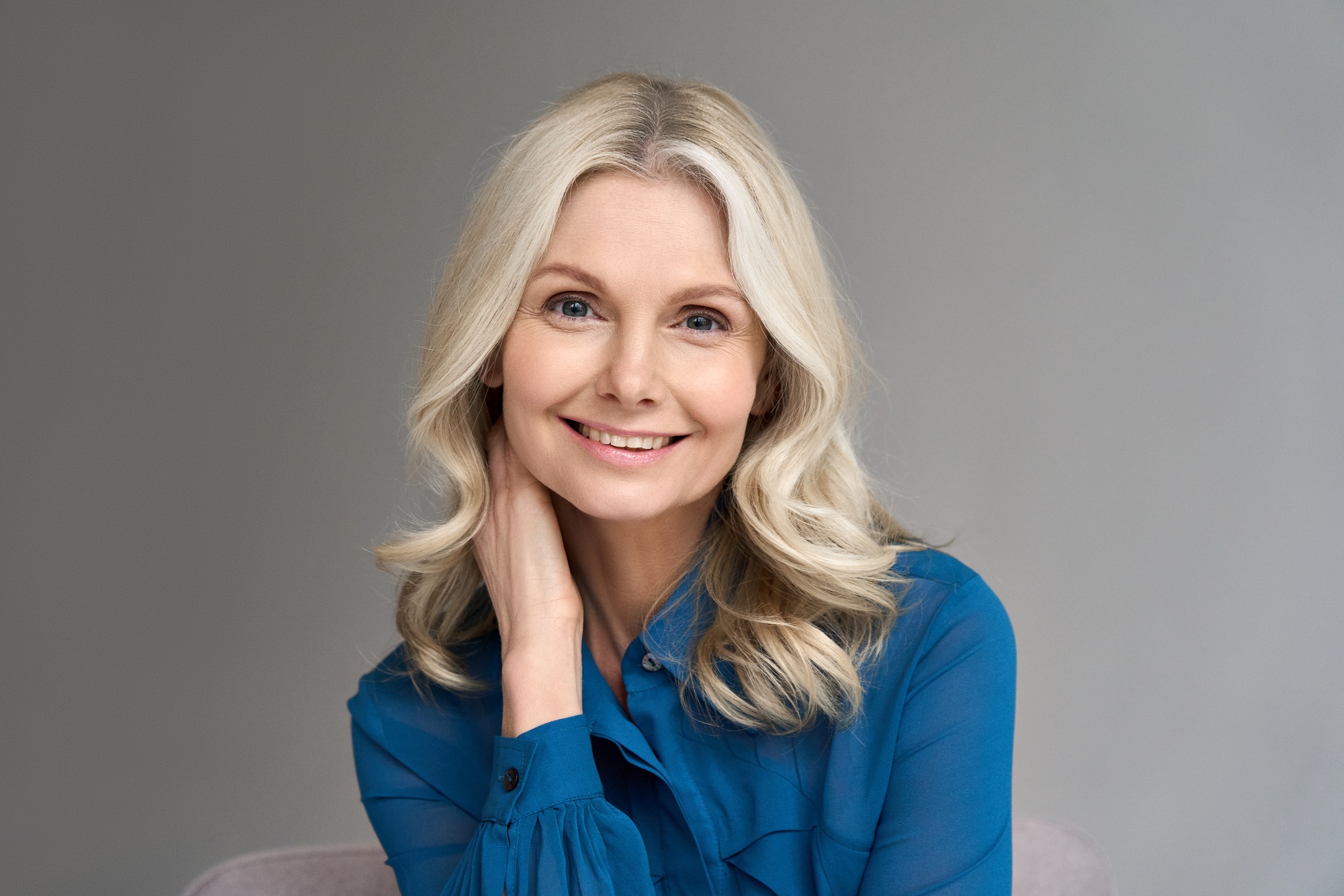 Portait of happy mature 50 years old business woman isolated on grey background.